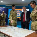 O secretário de Defesa, John Healey, recebe instruções ao se encontrar com militares durante uma visita ao Quartel-General Conjunto Permanente na RAF Northwood, em Hertfordshire, hoje.