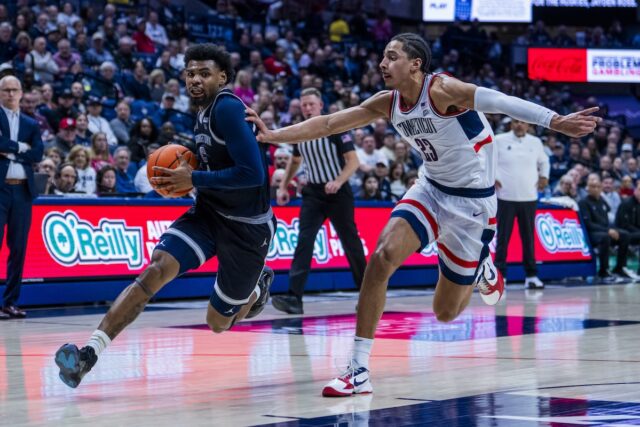 KJ Lewis drives against Jayden Ross of UConn Huskies