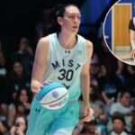 Breanna Stewart dribla uma bola de basquete em um estádio.