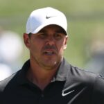 GettyImages-2267717697 Brooks Koepka consola jovem presa sob um carrinho de golfe