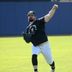 O arremessador do New York Yankees, Carlos Rodón, lança uma bola multicolorida no campo externo.