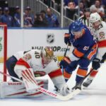 O pivô Casey Cizikas (53) do New York Islanders tenta um chute que ultrapassou o goleiro Daniil Tarasov (40) do Florida Panthers e o pivô Carter Verhaeghe (23) durante o primeiro período de um jogo na UBS Arena em Elmont, NY no sábado, 28 de março de 2026.