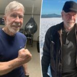 Chuck Norris com um boné de beisebol preto e jaqueta marrom em pé em um campo nevado.