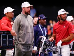 Como a TGL planeia revolucionar as apostas no golfe através do seu formato único TGL apresentado pela partida de golfe SoFi, Boston versus Bay, com um jogador de golfe balançando em um campo coberto em frente a uma tela grande exibindo os detalhes do jogo e um cenário digital de uma ponte em ruínas.