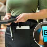 Ilustração de uma pessoa segurando um smartphone exibindo o logotipo Square.