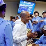 O técnico principal de basquete masculino da LIU, Rod Strickland, parabeniza os jogadores após serem selecionados para jogar contra o Arizona no torneio de basquete masculino da NCAA.