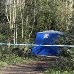 Uma tenda azul e fita policial foram montadas ao redor da área onde o corpo do homem foi encontrado