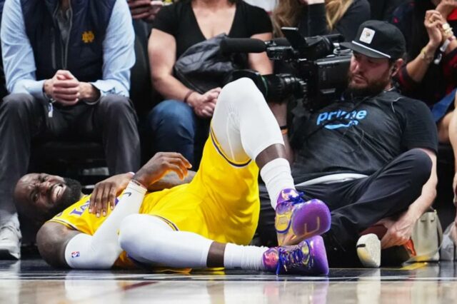 LeBron James faz uma careta de dor depois de cair enquanto subia para uma cesta contra Nikola Jokić durante o quarto período da derrota do Lakers por 120-113 para o Nuggets, em Denver, em 5 de março de 2026.