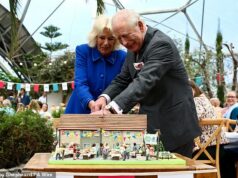 Cuidado com os dedos! Rei e Rainha usam uma espada para cortar uma fatia de bolo um pouco torta em visita ao Projeto Éden Charles, 77, e Camilla, 78, foram recebidos na atração popular para comemorar seu 25º aniversário e fizeram um passeio pelo projeto ambiental para conhecer seu trabalho inovador e objetivos para o futuro