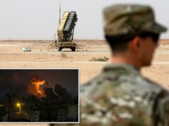 Dez americanos feridos em míssil iraniano e ataque de drone a base militar dos EUA na Arábia Saudita: relatório Um membro da Força Aérea dos EUA camuflado está em primeiro plano, de frente para uma bateria de mísseis Patriot na Base Aérea Prince Sultan, na Arábia Saudita.