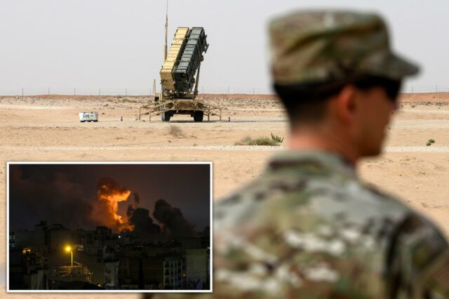 Dez americanos feridos em míssil iraniano e ataque de drone Um membro da Força Aérea dos EUA camuflado está em primeiro plano, de frente para uma bateria de mísseis Patriot na Base Aérea Prince Sultan, na Arábia Saudita.