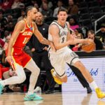 O armador do Brooklyn Nets, Egor Demin, dribla a bola enquanto é defendido pelo atacante do Atlanta Hawks, Zaccharie Risacher.