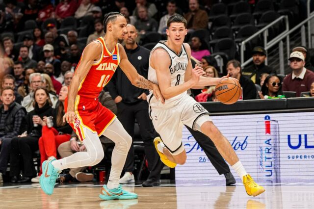 O armador do Brooklyn Nets, Egor Demin, dribla a bola enquanto é defendido pelo atacante do Atlanta Hawks, Zaccharie Risacher.