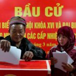 epa12820474 Pessoas olham as listas de candidatos em uma seção eleitoral em Hanói, Vietnã, em 15 de março de 2026. O Vietnã realiza eleições gerais para a 16ª Assembleia Nacional e Conselhos Populares em todos os níveis para o mandato 2026-2031, em 15 de março. EPA/LUONG TAILANDÊS LINH