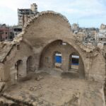 Nahed Barbakh, 60 anos, dono de loja e comerciante, sentado em uma mesa em frente à sua loja