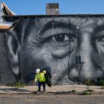 Trabalhadores retirando um busto de Cesar Chavez de um parque.