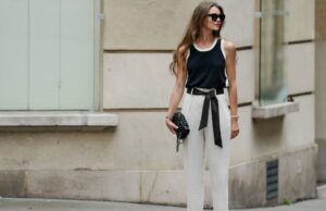 Estas 18 calças pull-on têm um controle de barriga surpreendentemente bom Jill Asemota vista usando óculos escuros vintage pretos, vestido longo de malha de lã cinza Dorothee Schumacher, jaqueta cardigã de malha de lã cinza Dorothee Schumacher combinando, meias de algodão brancas, tênis Samba de couro branco Adidas, em 04 de novembro de 2023 em Berlim, Alemanha.