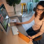 Uma pessoa usa um desktop e um tablet.