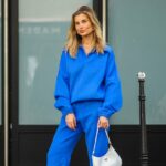 NOVA IORQUE, NOVA IORQUE - 14 DE SETEMBRO: Kate Smolianinova vista usando óculos de sol retangulares finos Vehla Eyewear em marrom escuro. Seu cabelo penteado em um corte elegante na altura do queixo com uma parte central suave. Uma blusa Kobi Halperin de renda branca transparente com bordado floral, gola alta com babados, mangas volumosas e bordas recortadas, combinada com jeans Kobi Halperin azul de cintura alta com detalhes em jacquard floral tonal e uma bolsa de couro marrom macio Gerard Darel com pregas franzidas e alças arredondadas, fora do desfile de Ulla Johnson, durante a New York Fashion Week, em 14 de setembro de 2025 na cidade de Nova York. (Foto de Jeremy Moeller/Getty Images)