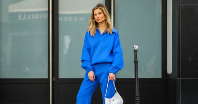 NOVA IORQUE, NOVA IORQUE - 14 DE SETEMBRO: Kate Smolianinova vista usando óculos de sol retangulares finos Vehla Eyewear em marrom escuro. Seu cabelo penteado em um corte elegante na altura do queixo com uma parte central suave. Uma blusa Kobi Halperin de renda branca transparente com bordado floral, gola alta com babados, mangas volumosas e bordas recortadas, combinada com jeans Kobi Halperin azul de cintura alta com detalhes em jacquard floral tonal e uma bolsa de couro marrom macio Gerard Darel com pregas franzidas e alças arredondadas, fora do desfile de Ulla Johnson, durante a New York Fashion Week, em 14 de setembro de 2025 na cidade de Nova York. (Foto de Jeremy Moeller/Getty Images)