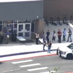 Um policial parado do lado de fora da Hill Country College Preparatory High School.