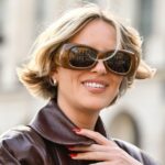 Aline Kaplan vestindo calças jeans azuis de perna larga Baum & Pferdgarten e outras histórias blusa cortada com padrão de flores brancas e salto laranja de verão e tons laranja preto Mango em 06 de junho de 2023 em Berlim, Alemanha.