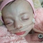 Um menino sentado em uma cama de hospital