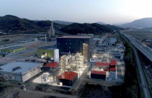 Group14 abre fábrica para produzir materiais de bateria para EVs com carregamento flash A battery materials factory is lit up at dusk.