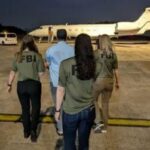 Agentes do FBI escoltam Zobaidul Amin até um avião.