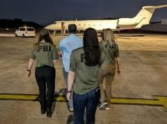 Homem de Bangladesh acusado de enganar centenas de adolescentes para que lhe enviassem imagens pornográficas é trazido para os EUA Agentes do FBI escoltam Zobaidul Amin até um avião.