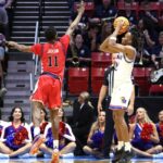 O jogador do St. John's Red Storm, Ian Jackson, salta para bloquear um chute do jogador do Kansas Jayhawks, Darryn Peterson, durante o torneio da NCAA.