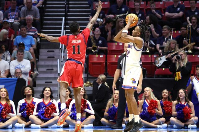 O jogador do St. John's Red Storm, Ian Jackson, salta para bloquear um chute do jogador do Kansas Jayhawks, Darryn Peterson, durante o torneio da NCAA.