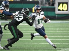 Jaxon Smith-Njigba consegue um contrato de US$ 168 milhões depois de ajudar os Seahawks a vencer o Super Bowl Dois jogadores de futebol, um com camisa branca e outro com camisa preta, em ação durante um jogo.