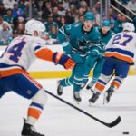 Jean-Gabriel Pageau (44) patina no gelo enquanto Michael Misa (77) verifica durante a vitória dos Islanders por 2 a 1 na prorrogação sobre os Sharks em 7 de março de 2026 em San Jose, Califórnia.