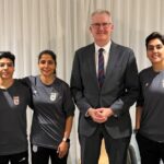 Nesta foto fornecida pelo gabinete do Ministro de Assuntos Internos da Austrália, Tony Burke, o Ministro Tony Burke, no centro, posa em um local não revelado com cinco jogadoras de futebol iranianas que receberam asilo na Austrália, terça-feira, 10 de março de 2026. (Ministério de Assuntos Internos da Austrália via AP)