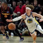 O armador do Warriors, Brandin Pod Ziemia (2), persegue uma bola perdida com o atacante do Atlanta Hawks, Jonathan Kuminga