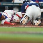 Juan Soto desliza pela base para marcar, enquanto o receptor sul-coreano está de joelhos atrás dele.