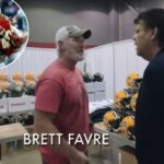 Brett Favre conversando com um homem em uma cabine cheia de capacetes Riddell.
