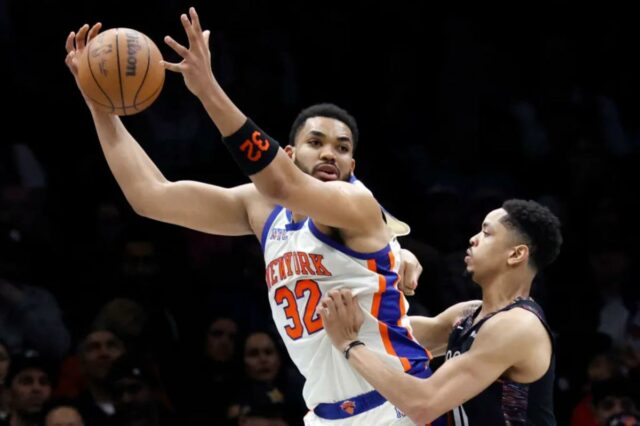Karl-Anthony Towns, que marcou 26 pontos e pegou 15 rebotes, tenta atacar Josh Minott durante a vitória dos Knicks por 93-92 sobre o Nets em 20 de março de 2026 no Barclays Center.