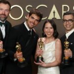 Sam Davis, segundo à direita, e Jack Piatt, à direita, aceitam um dos dois Oscars empatados de melhor curta-metragem de ação ao vivo por The Singers