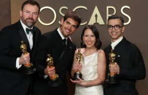 Laço do Oscar! Dois filmes venceram na mesma categoria pela primeira vez em mais de uma década Sam Davis, segundo à direita, e Jack Piatt, à direita, aceitam um dos dois Oscars empatados de melhor curta-metragem de ação ao vivo por The Singers