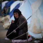 epa12853726 Residentes deslocados sentam-se do lado de fora de uma tenda em uma escola local depois de fugirem de suas casas no sul do Líbano após ataques aéreos israelenses, em Beirute, Líbano, em 27 de março de 2026. De acordo com a Unidade de Gestão de Desastres do governo libanês, em 27 de março de 2026, mais de 1.785.000 pessoas foram deslocadas internamente em abrigos coletivos no Líbano desde que a escalada começou em 2 de março. EPA/WAEL HAMZEH