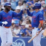 Os jogadores do New York Mets, Luis Robert Jr. (88) e Tyrone Taylor (15), cumprimentam-se.