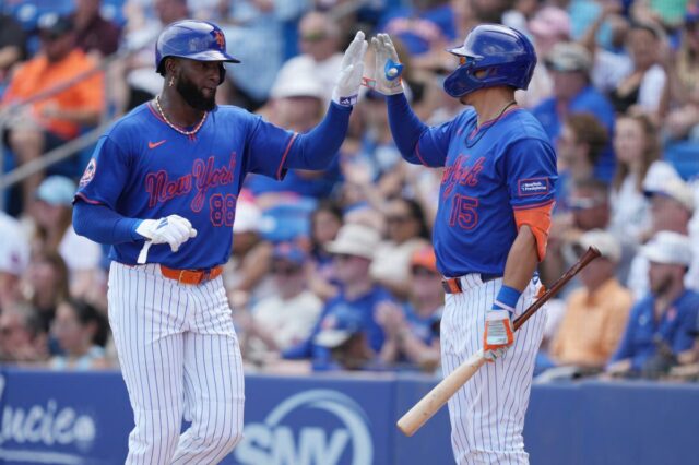 Luis Robert Jr. permanece aquecido após o início tardio do Os jogadores do New York Mets, Luis Robert Jr. (88) e Tyrone Taylor (15), cumprimentam-se.