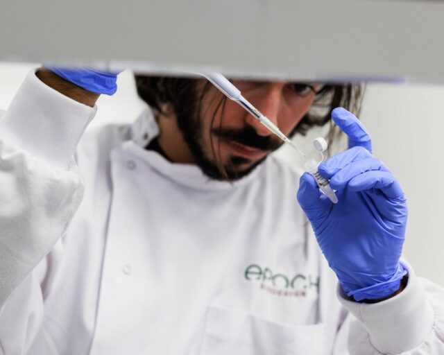 A man pipettes a liquid into a small tube.