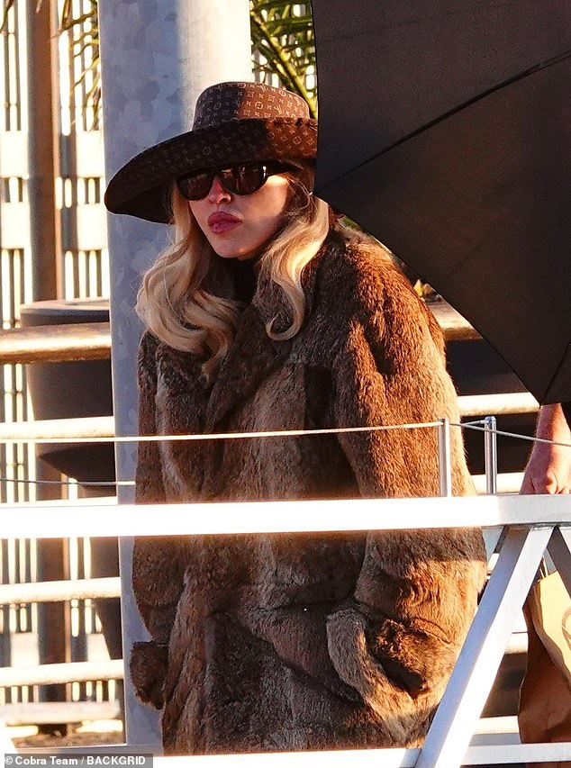 Madonna, 67 anos, veste um casaco de pele enquanto aproveita Madonna embrulhada em um casaco de pele marrom ao sair em Veneza com seu namorado Akeem Morris na sexta-feira