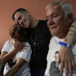 Andry Hernandez, um migrante venezuelano deportado meses atrás para El Salvador pelos Estados Unidos sob uma repressão à imigração, mostra tatuagens nos pulsos que dizem