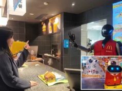 McDonalds em cidade chinesa pilota robôs humanóides para servir refeições e cumprimentar clientes Uma mulher interagindo com um robô humanóide vestindo um colete do McDonald's em um balcão.