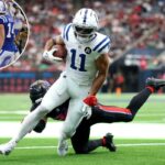 O wide receiver do Indianapolis Colts, Michael Pittman Jr., carregava a bola de futebol enquanto fugia do safety Jalen Pitre do Houston Texans.