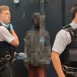 Uma foto tirada na sequência capturou o homem olhando para o público enquanto a polícia o detinha depois que ele aterrorizou uma mulher cega ao invadir sua casa.